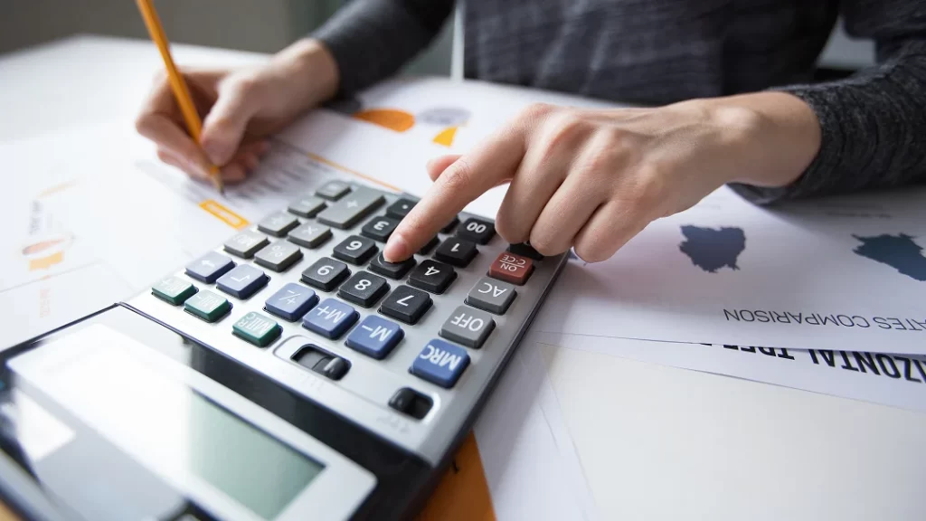 Une personne utilise une calculatrice pour effectuer des calculs.