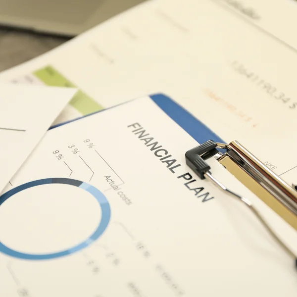 Financial plan on paper with a pen and calculator, symbolizing careful financial decision-making.