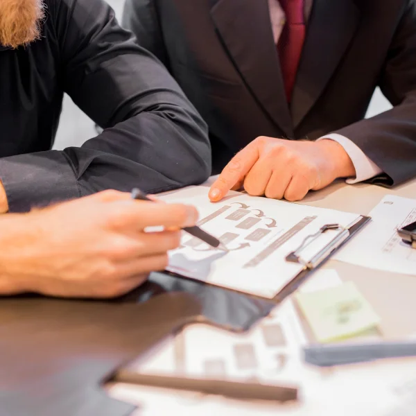 Deux professionnels assis à une table, examinant des documents liés à l'insolvabilité.