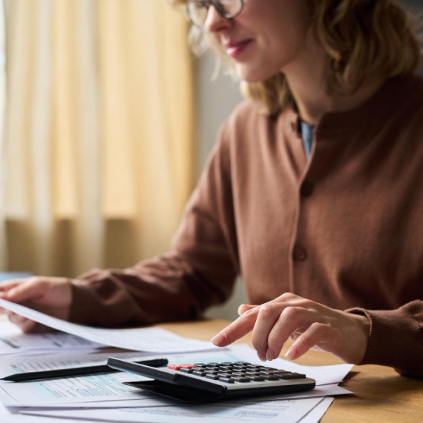 Personne analysant ses finances et calculant un plan de gestion de la dette avec un conseiller en crédit.