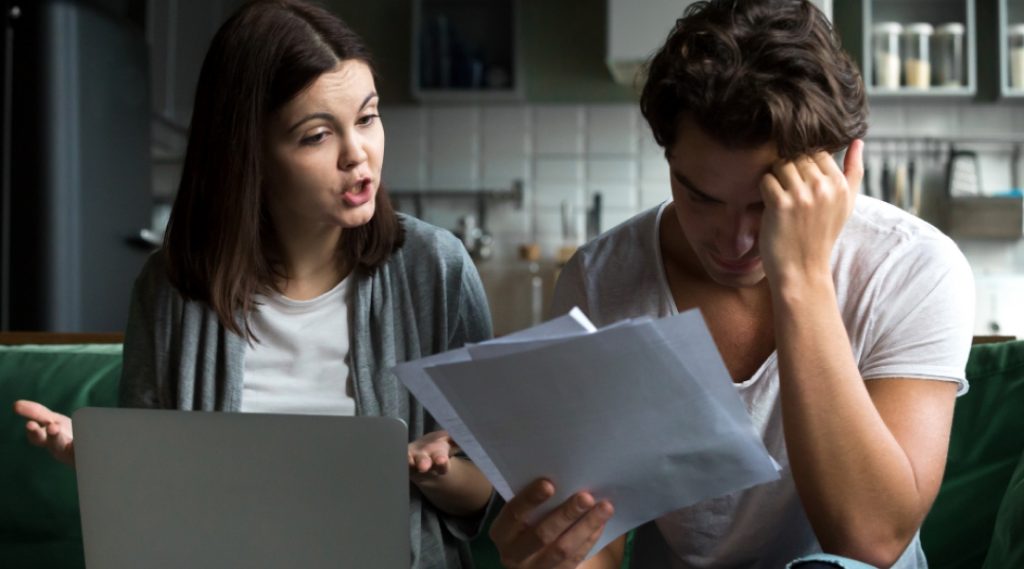Couple examinant des documents financiers avec un conseiller afin d’évaluer des solutions avant de déclarer une faillite.