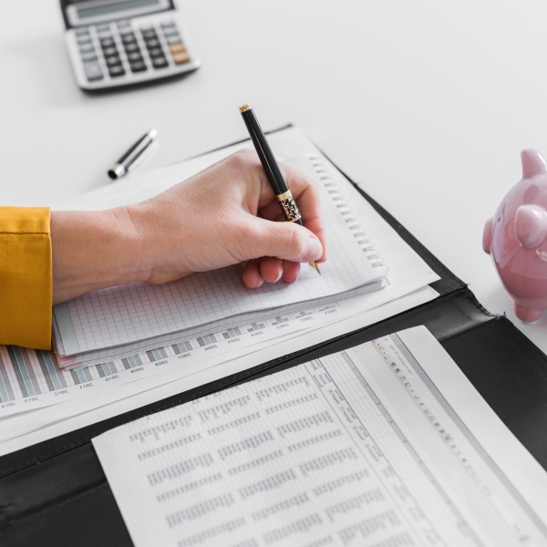 Personne organisant ses finances et prenant des notes pour comprendre la consolidation de dettes à Fabreville